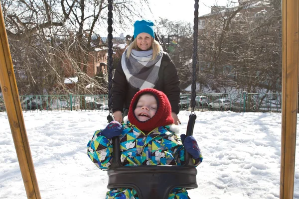 Çocuk kışın salıncak üzerinde