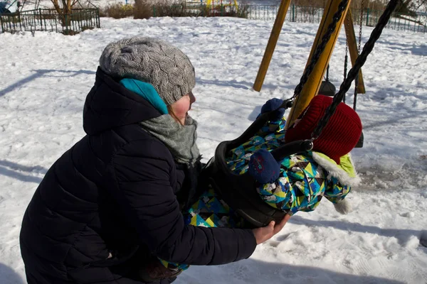 Çocuk kışın salıncak üzerinde