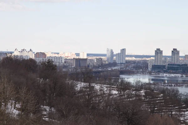 Kiev, 24 de março de 2018, Ucrânia. Vista da cidade e imobiliário através do rio de inverno no gelo — Fotografia de Stock