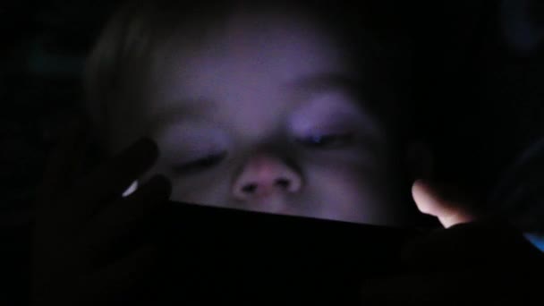 Chłopiec dwa lata oglądać bajki na swoim tablecie w nocy — Wideo stockowe
