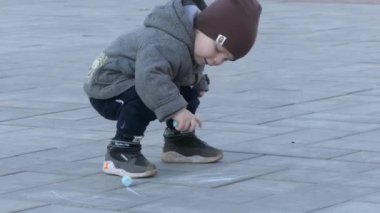 Çocuk parkta kaldırımda başlamadı. Bebek resimleri tebeşir ile.