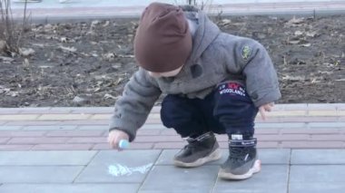 Çocuk parkta kaldırımda başlamadı. Bebek resimleri tebeşir ile.