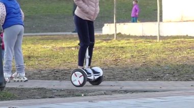 Kiev, Ukrayna - 8 Nisan 2018: Genç kız arkadaş bacaklar Jeans Park Segway Gyroboards binme keyfini çıkarın..