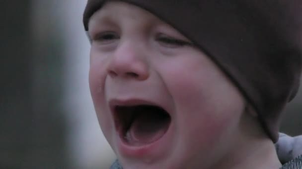 泣いている子の少年 通りで泣いている帽子のクローズ アップ 歳の子 子供がお菓子を拒否します — ストック動画