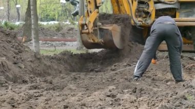 Kiev, 19 Nisan 2018, Ukrayna: Ekskavatör kova yere kazıyor. İşçi siper teyp metre ölçme bir inşaat ile ölçer..