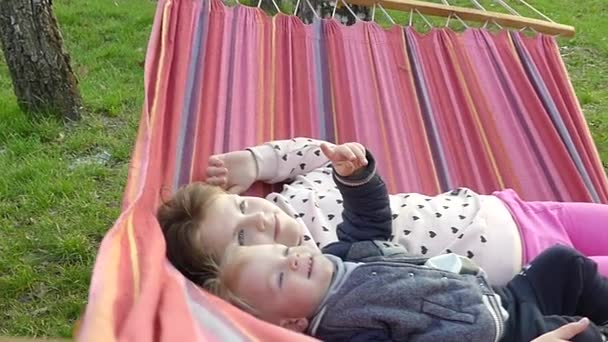 Crianças Descansam Uma Rede Colorida Parque Cidade Durante Pôr Sol — Vídeo de Stock