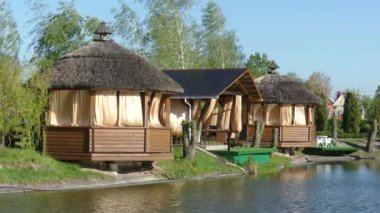 Kiev, 2 Mayıs 2018, Ukrayna: Göl kıyısında ahşap pergolalar. Çardak perdeler rüzgarda geliştirmek. Thatched çatı.