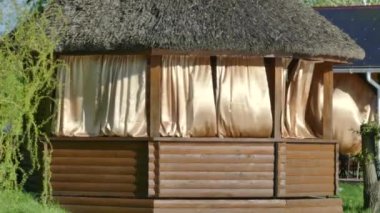 Kiev, 2 Mayıs 2018, Ukrayna: Göl kıyısında ahşap pergolalar. Çardak perdeler rüzgarda geliştirmek. Thatched çatı.