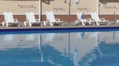 İnsanlar olmadan havuz kenarında plastik şezlong.