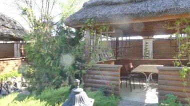 Ahşap pergolalar yeşil bitkilerde. Thatched çatı