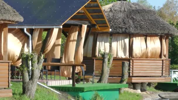 2018 キエフ 湖の岸に木製パーゴラ 風のガゼボでカーテンを開発します 茅葺き屋根 — ストック動画