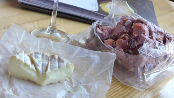 2018 キエフ 女性の手の背景のテーブルにフランス産チーズの頭カット燻製肉とソーセージ包装 — ストック動画