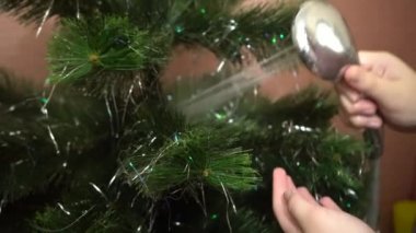 Yeni yıla hazırlanıyorduk. Genç kız banyoda yapay bir Noel ağacı yıkıyor. Duşta Noel ağacı.