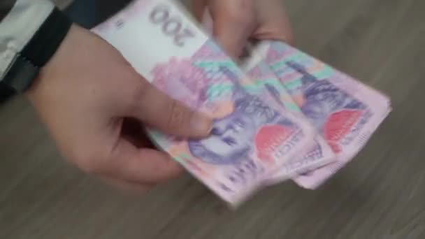 女性の手はウクライナのお金を数える 木製のテーブルの背景にウクライナのグリブナ 女の子カウント — ストック動画