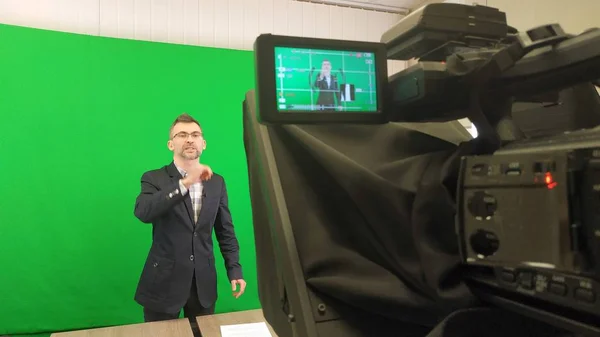 Um blogueiro está gravando um vídeo em um fundo verde. Registro a v — Fotografia de Stock