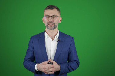 Bir blogcu yeşil arka planda bir video kaydediyor. Camco.