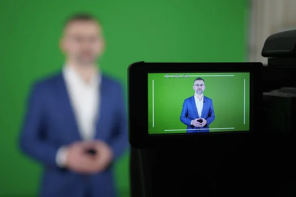 Un bloguero está grabando un video sobre un fondo verde. El camco — Foto de Stock