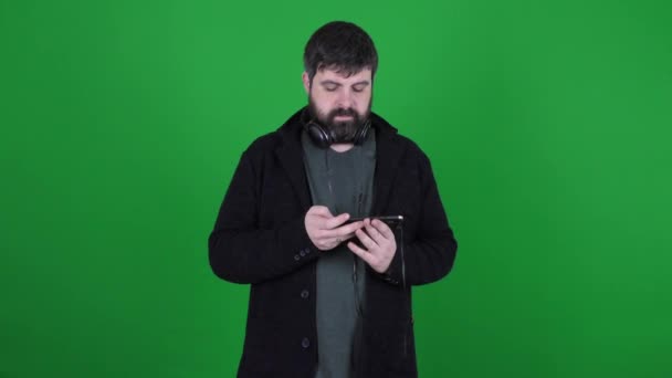 Vousatý Muž Sluchátkách Komunikuje Skypu Zeleném Pozadí Vousatý Muž Sluchátkách — Stock video
