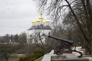Chernihiv, Ukraine - February 2020: View of the domes of the church. City view, people walk around the city against the background of the church.