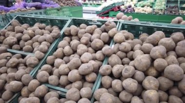 Avrupa, Kiev, Ukrayna, Şubat 2020: Bir kadın pazarda patates seçiyor. Marketteki bir rafta sebzeler. Marketteki sebze reyonu..