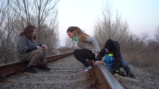 Genç Çocuklu Bir Kız Demiryolunda Oturuyor Çocuklar Demiryolunda Oynuyor — Stok video