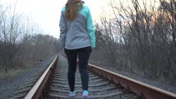 这个女孩坐火车去 一个寂寞的姑娘沿着铁轨走着 — 图库视频影像