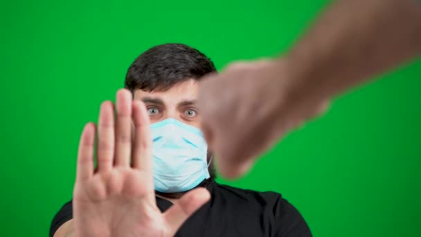 仮面の髭を生やした男が防腐剤と冗談で手を汚している 緑の背景に Covid 19コロナウイルスのパンデミックの間のウェルカムサイン ストップは手を示しています 握手だ 会議へようこそ ウイルスの拡散 — ストック動画