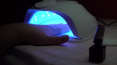 Koronavirüs karantinası sırasında kız manikür yaptırıyor. Bir kadın kendi manikürünü yapar..