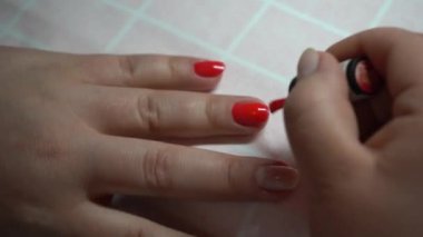 Koronavirüs karantinası sırasında kız manikür yaptırıyor. Bir kadın kendi manikürünü yapar..