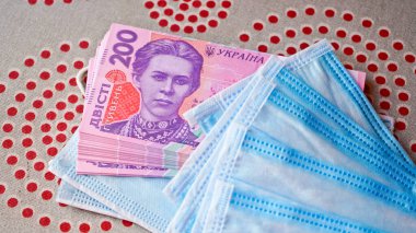 Paralı tıbbi maskeler. Koruyucu maskeli Ukrayna parası. Tıbbi maske hayranı bir Ukrayna Hryvnia hayranı..