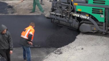 Avrupa, Kiev, Ukrayna - Mayıs 2020: Paver bir yol inşa etti. Yol tamiri. İnşaatçılar asfalt döşüyorlar. Yeni asfalt.