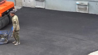 Avrupa, Kiev, Ukrayna - Mayıs 2020: Yol Tamiri. İnşaatçılar asfalt döşüyorlar. Buz pateni pisti yeni asfalt rulo.