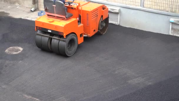 Europe, Kiev, Ukraine - May 2020: Road Repair. Builders are laying asphalt. Skating rink rolls new asphalt. — Stock Footage Europe Kiev Ukraine May 2020 Road Repair Builders Laying Asphalt Royalty Free Stock Video
