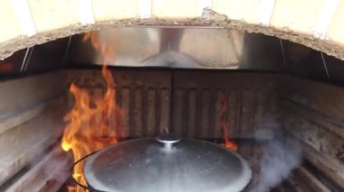 Ateşin üstünde bir tencere. Izgaradaki ateşte balık çorbası pişirmek.