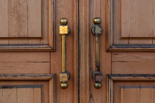 Porta de madeira velha fechada com alças — Fotografia de Stock