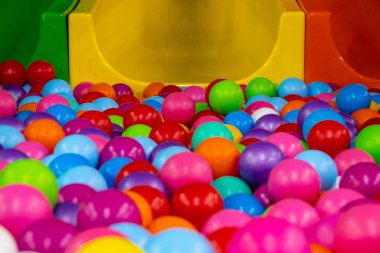 Kaydırağın yanındaki oyun odasında çok renkli plastik toplar var.