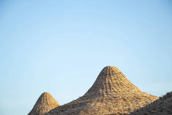 Wicker umbrella on a hotel beach in egypt on a sunny day — ストック写真