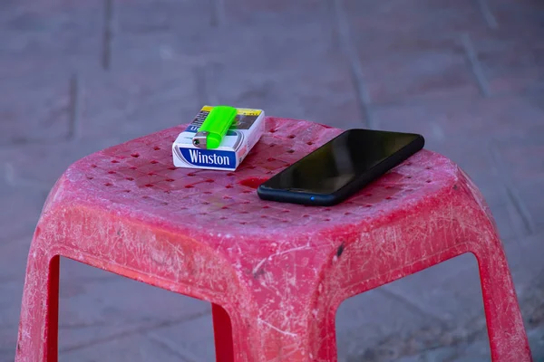 Sharm El Sheikh, Mısır - 18 Aralık 2019. Sokakta bir bankta bir paket sigara ve bir telefon var..