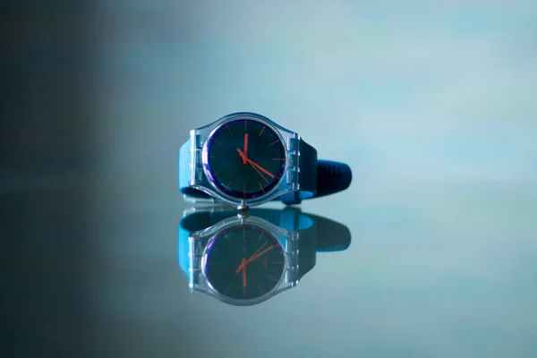 Reloj azul de los hombres se encuentra en la mesa y se refleja en ella — Foto de Stock
