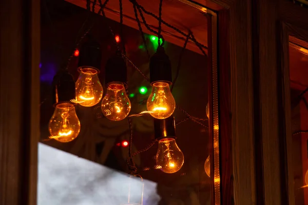 Χριστουγεννιάτικα φώτα στο βραδινό παράθυρο του σπιτιού — Φωτογραφία Αρχείου