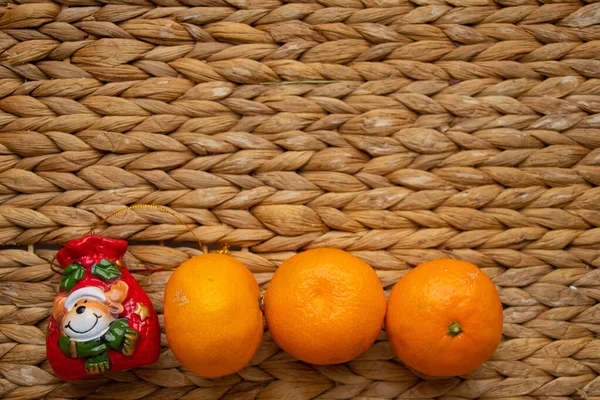 Juguete navideño con mandarinas sobre fondo de paja —  Fotos de Stock