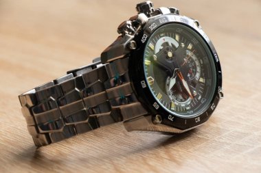 Erkeklerin saati güneş ışığında bir masanın üzerinde yatıyor.