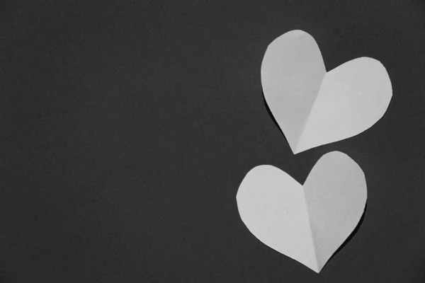 Vystřižené z papíru srdce leží na papíře, Valentýn, černá a bílá fotografie — Stock fotografie