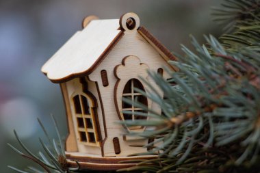 Noel ağacının dallarında küçük ahşap bir ev