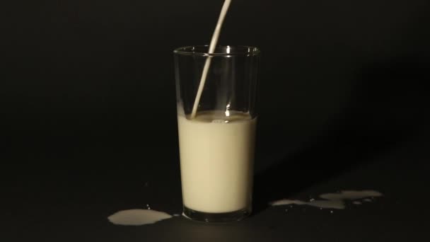 Melk Een Beker Gieten Een Geïsoleerde Donkere Achtergrond — Stockvideo