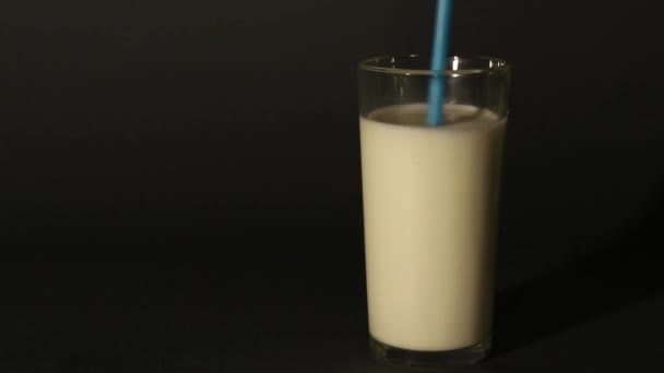 Milch Einer Tasse Mit Strohhalmen Auf Einem Isolierten Dunklen Hintergrund — Stockvideo