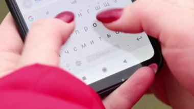 Kız dokunmatik bir telefonla mesaj yazıyor.