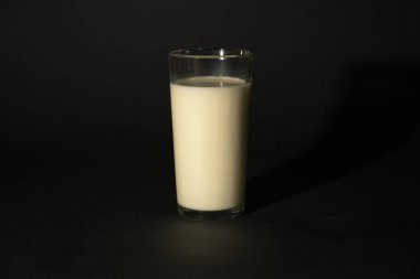 Koyu izole edilmiş arka planda sütlü bardak.