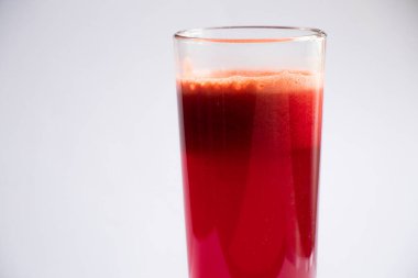 Bir bardak taze havuç, izole bir arka planda pancar suyu.