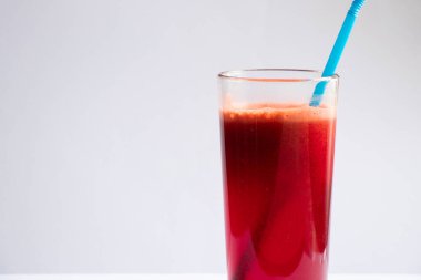 Bir bardak taze havuç, izole bir arka planda pancar suyu.